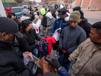 Migrants look through donated clothing on a street in downtown El Paso, Texas, Sunday, Dec. 18, 2022. Texas border cities were preparing Sunday for a surge of as many as 5,000 new migrants a day across the U.S.-Mexico border as pandemic-era immigration restrictions expire this week, setting in motion plans …