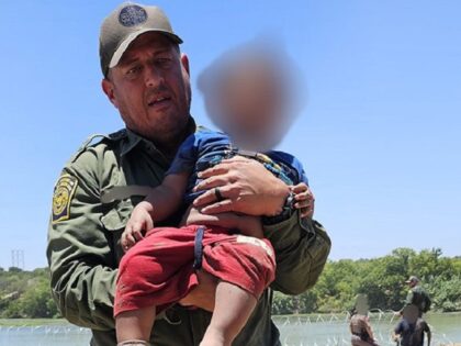 A Border Patrol agent carries a severely dehydrated migrant child rescued from the bank of the Rio Grande. (U.S. Border Patrol/Del Rio Sector)