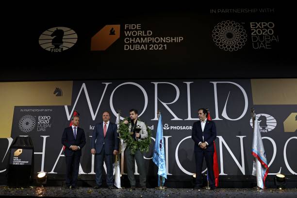Norway's grandmaster Magnus Carlsen celebrates on stage with the FIDE World Chess Championship trophy, at the Dubai Expo 2020 in the Gulf emirate, on...