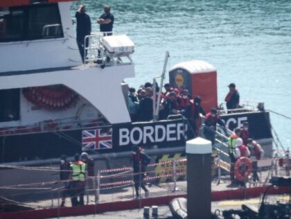 Migrants are escorted ashore from a UK Border Force vessel in Dover, southeast England, on June 15, 2023, after having been picked up at sea while attempting to cross the English Channel. At least 7,610 people have been detected in small boats off Britain's coast so far this year, according …