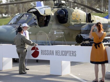 A woman as she takes a photo of a Russian military helicopter KA-52 at the ADEX 2014 International Defence Industry Exhibition in Baku on September 11, 2014. This event showcases products like armoured and unarmoured vehicles, Command and control systems, ammunition and their components, body armuor and personal protection system, …