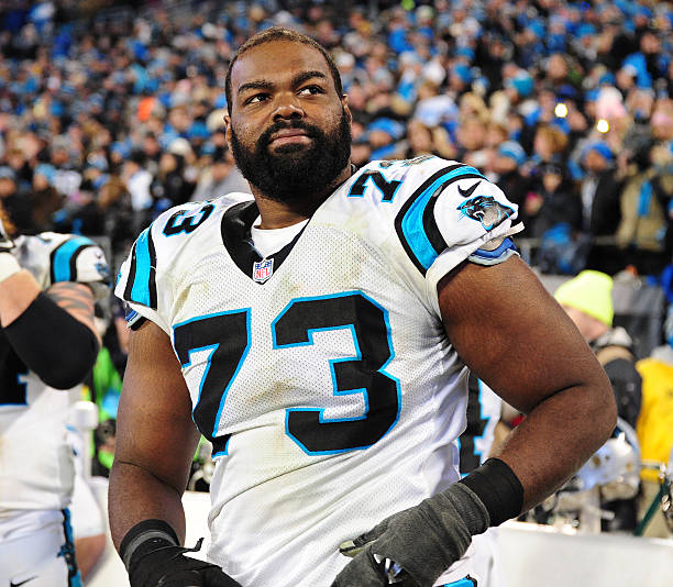 Michael Oher of the Carolina Panthers watches play against the Arizona Cardinals during the NFC Championship Game at Bank Of America Stadium on...