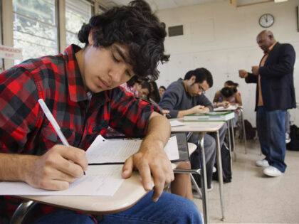 Students writing in classroom - stock photo