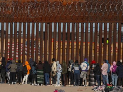 Migrants queue at the border wall to be received by Border Patrol agents after crossing the Rio Bravo river (or Rio Grande river, as it is called in the US) from Ciudad Juarez, Chihuahua state, Mexico to El Paso, Texas, US on December 21, 2022. - Title 42, a President …