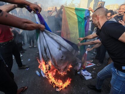 30 June 2023, Iraq, Baghdad: Protesters burn the LGBT (lesbian, gay, bisexual and transgender) flag during a protest against the burning a copy of the Quran in Sweden. Photo: Ameer Al-Mohammedawi/dpa (Photo by Ameer Al-Mohammedawi/picture alliance via Getty Images)