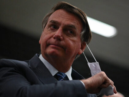 Brazil's President Jair Bolsonaro removes his protective face mask to speak to journalists during a press conference amidst the Coronavirus (COVID-19) pandemic at Galeao Airport in Rio de Janeiro, Brasil, on May 5, 2021. (Photo by Andre Borges/NurPhoto via Getty Images)