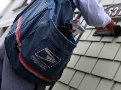 SAN FRANCISCO - JULY 30: US Postal Service letter carrier Anthony Ow places letters in a mailbox as he walks his delivery route July 30, 2009 in San Francisco, California. The US Postal Service is expecting their budget deficit to reach $7 billion, up from earlier projections of $6 billion. …