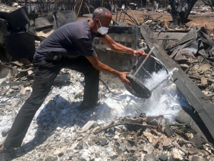 Anthony M. La Puente, 44, recovers items from his house in the aftermath of a wildfire in Lahaina, western Maui, Hawaii on August 11, 2023. A wildfire that left Lahaina in charred ruins has killed at least 55 people, authorities said on August 10, making it one of the deadliest …