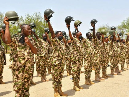 Soldiers gesture while standing on guard during Nigerian President Muhammadu Buhari's visit to the Maimalari Barracks in Maiduguri on June 17, 2021. (Photo by Audu Marte / AFP) (Photo by AUDU MARTE/AFP via Getty Images)
