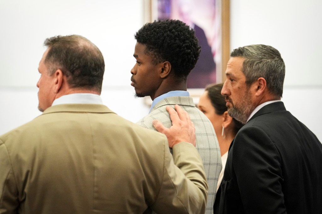 Antonio Armstrong Jr's lawyer places a hand on his client's back in court. 