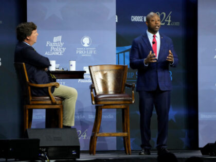 Republican presidential candidate Sen. Tim Scott, R-S.C., speaks during the Family Leadership Summit as moderator Tucker Carlson, left, looks on, Friday, July 14, 2023, in Des Moines, Iowa. (AP Photo/Charlie Neibergall)